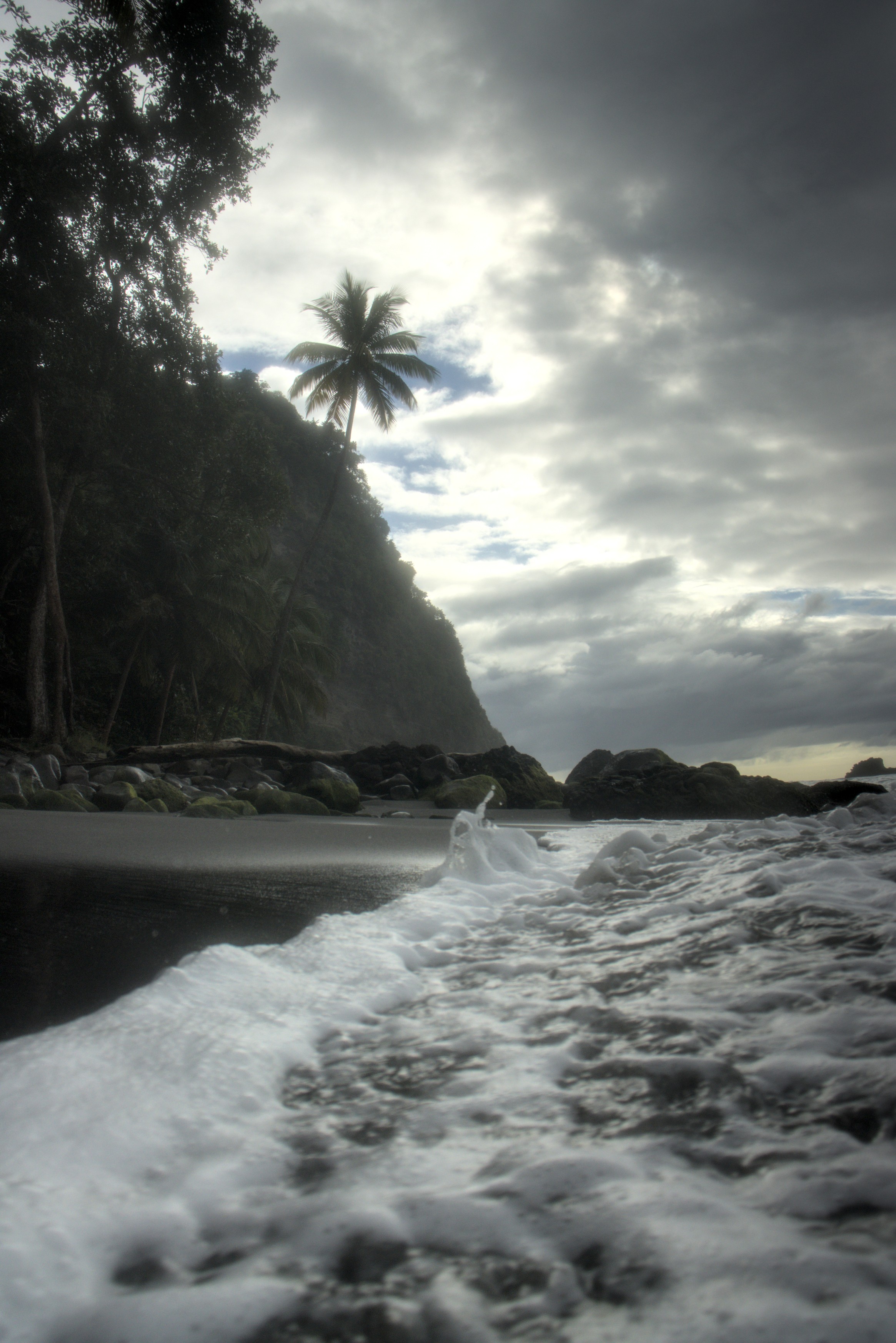 Strand, Palmen, Felsen und Wolken